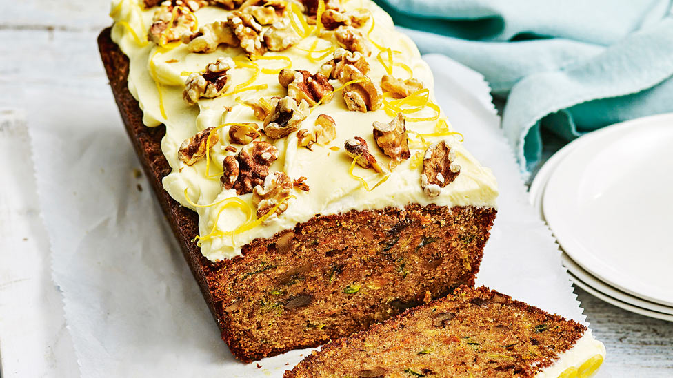 Zucchini and carrot cake topped with cream cheese icing and lemon zest and extra walnuts