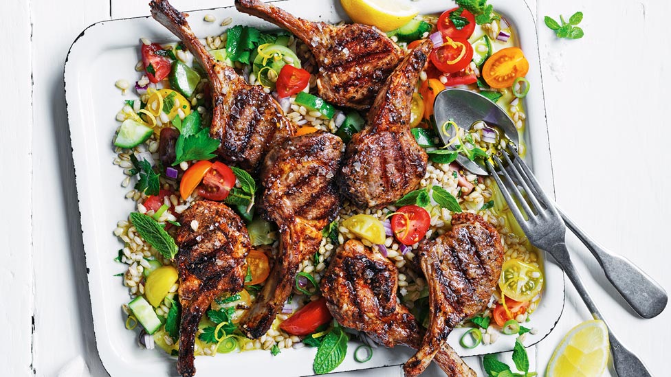 Lamb chops served on top of salad greens with cherry tomatoes