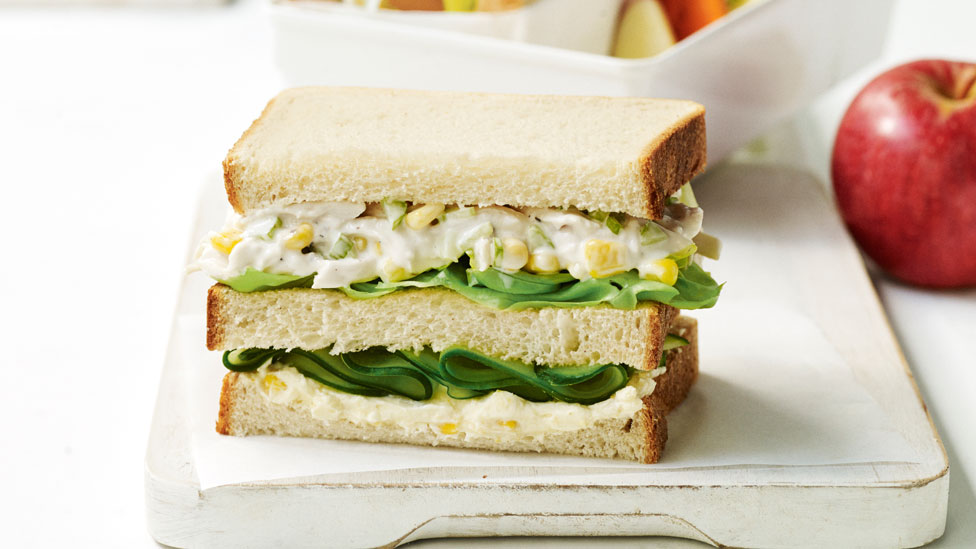 A corn and chicken stacked sandwich with salad