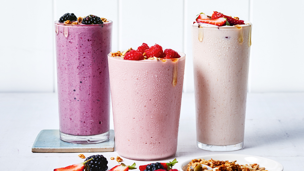 3 glasses of mixed berry smoothies with berries on top