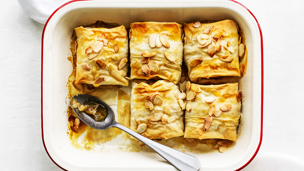 Five honey-glazed apple dumplings sprinkled with almonds