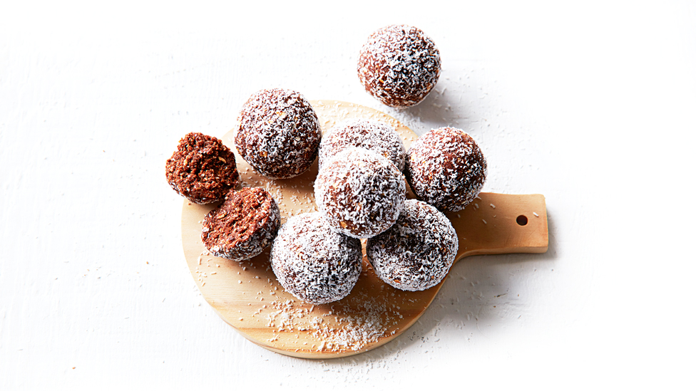 Seven nut-free cacao and coconut bliss balls and one cut in half