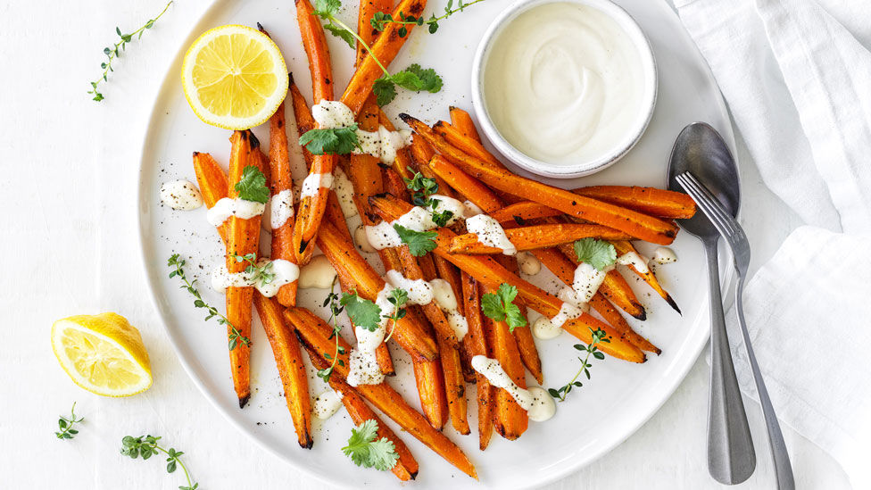 Roasted carrots with tahini-yoghurt sauce and lemon wedges