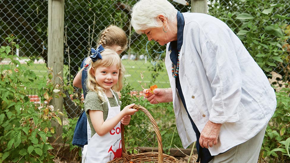 A photo of the Stephanie Alexander picking produce with a child