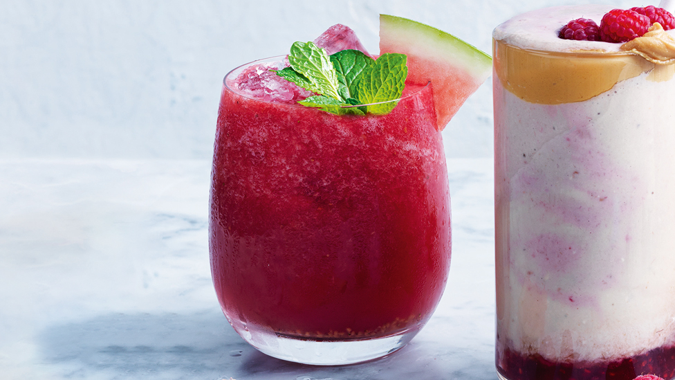 Berry and watermelon juice topped with ice cubes, watermelon wedges and mint