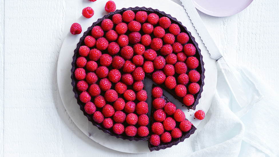 Raspberry chocolate tart covered with raspberries
