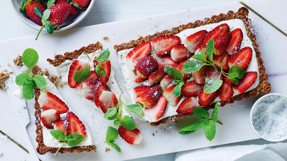 Yoghurt and strawberry tart with mint sugar cut in pieces