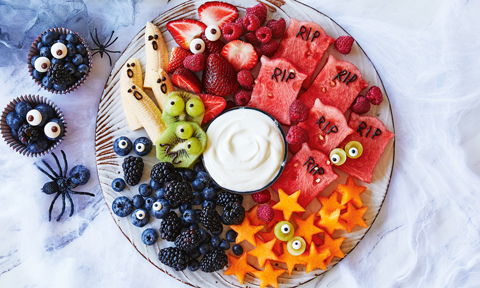 Funny fruit platter with five different fruits and greek style yoghurt