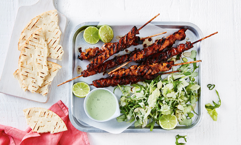 Kebabs with gyros salad and lime wedges
