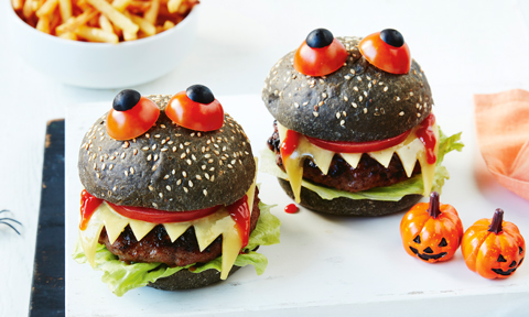 Two monster burgers decorated with tomato and blueberry
