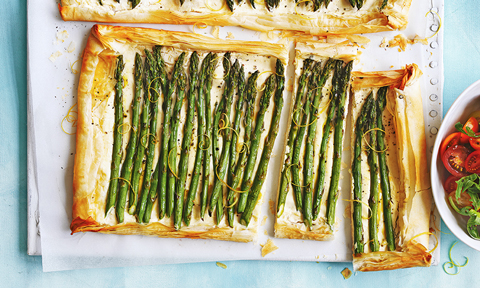 Ricotta and asparagus tarts cut in large pieces, served with tomato and rocket leaves