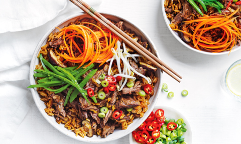 Slow cooker beef and rice hot pot topped with snow peas and carrot