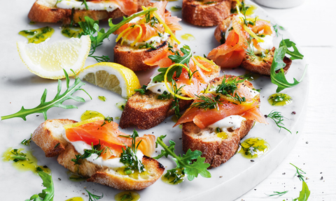 Seven smoked salmon toasts topped with herbs