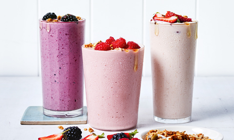 3 glasses of mixed berry smoothies with berries on top 