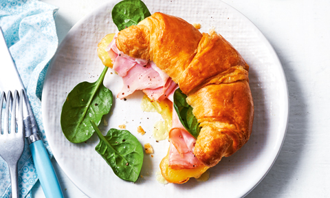 A ham and cheese croissant with spinach