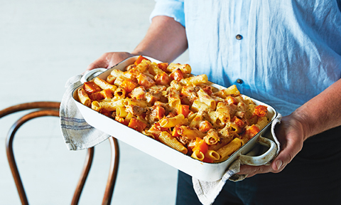 Tuna pasta bake made with roast pumpkin being held by a chef