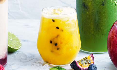 Passionfruit, mango and orange fizz top with ice and mint leavesa