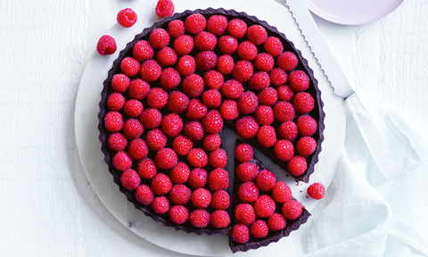 Raspberry chocolate tart covered with raspberries