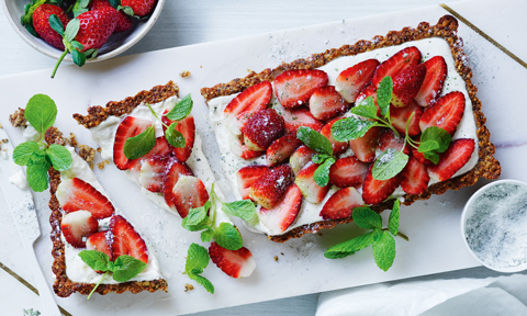Yoghurt and strawberry tart with mint sugar cut in pieces