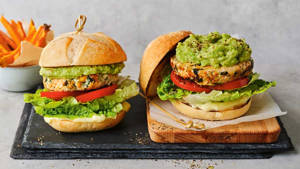 Spanakopita chicken burgers with avocado and sweet potato fries in background