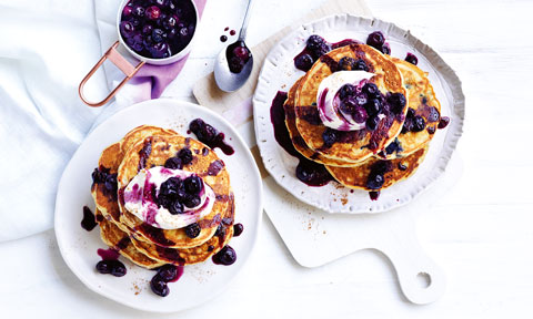 Pumpkin and blueberry pancakes topped with whipped cream and blueberries