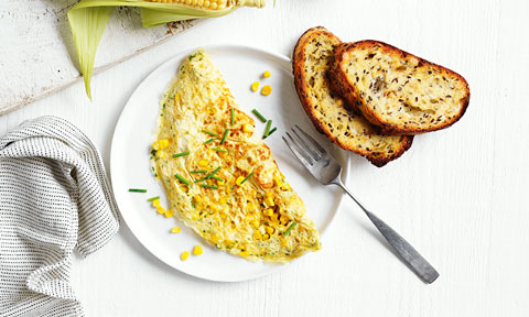 Cheesy omelette filled with corn, chives and cheddar