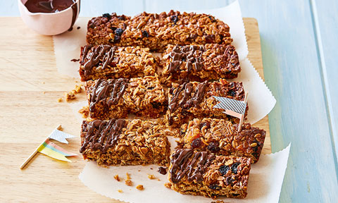 Whole apricot and oat muesli slice cut into 8 slices with melted chocolate topping