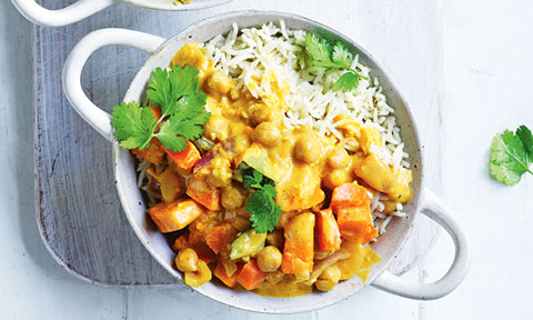 Chickpea curry served in a bowl with rice and coriander on top