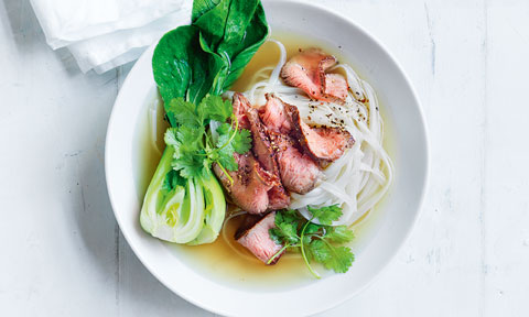 Bowl of beef pho with vermicelli noodles, beef and bok choy