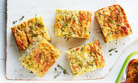 Five squares of tuna and zucchini slice served on a chopping board