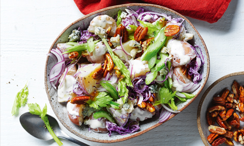 Red cabbage, potatoes, celery and walnut salad served in a bowl with walnuts on the side