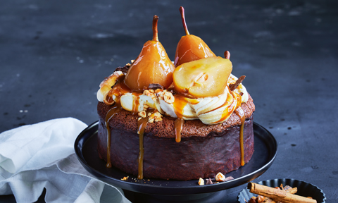 Whole sticky pear chocolate mud cake with whipped cream, caramel and two whole pears on top