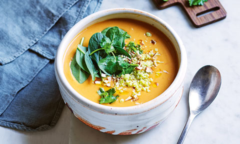 Sweet potato soup served a bowl with spinach and sambal on top