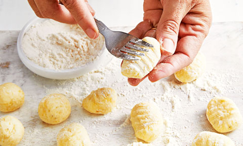 Gnocchi being pressed with a fork