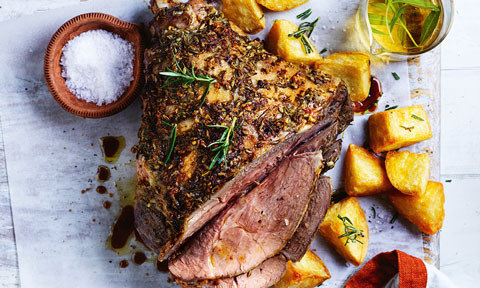 Roast lamb with crispy potatoes served alongside a dish of salt and rosemary olive oil