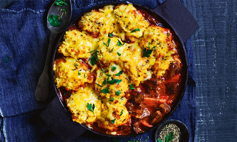 Slow cooker beef with cheesy dumplings in a baking dish