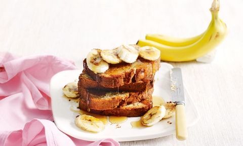Banana bread on a plate served with sliced bananas