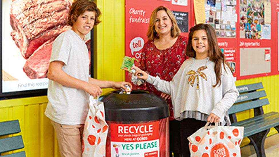 Families in front of a REDcycle bin