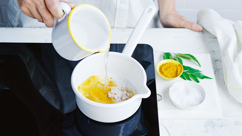 Pouring water to the saucepan with a mixture of pickling liquid