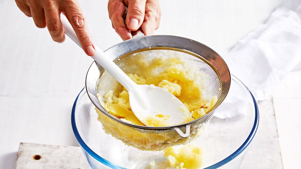 Potatato being stained through a sieve 