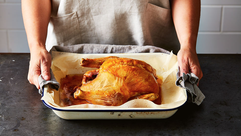 A whole chicken in a roast pan