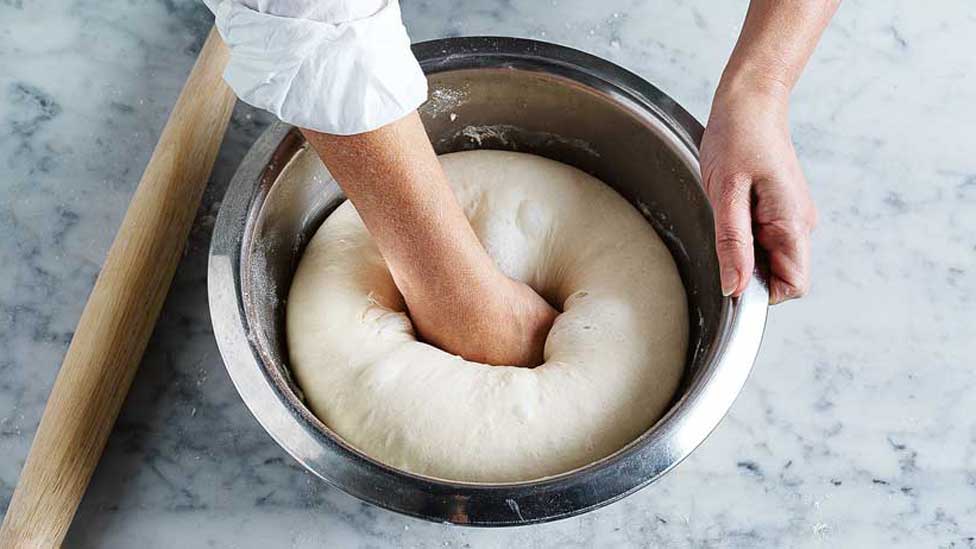 Punch down the dough in the bowl after resting