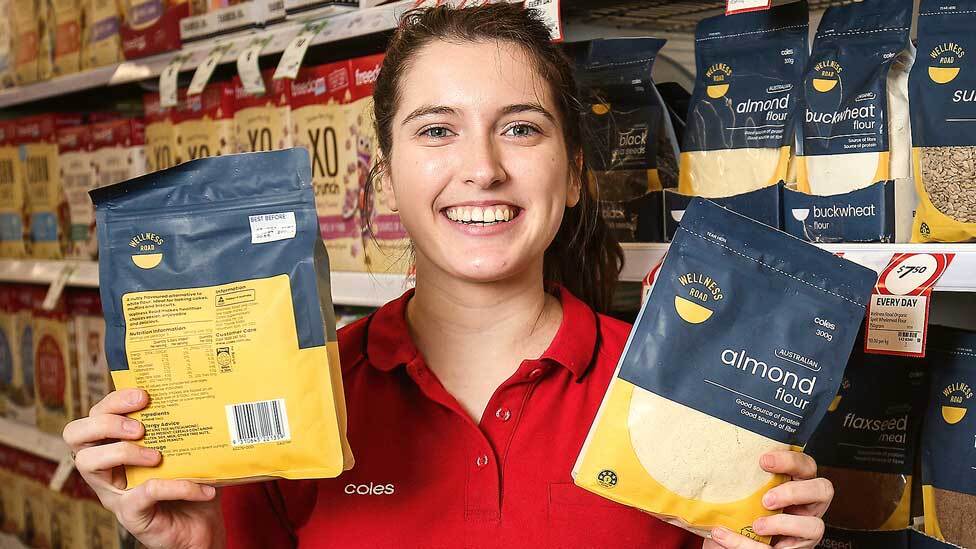 Coles staff holding two bags of Wellness road almond flour