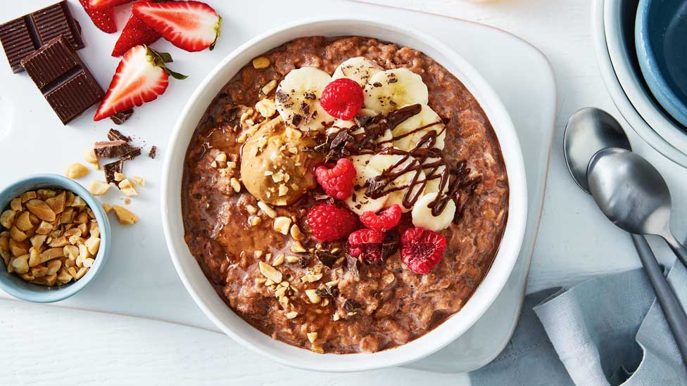 Breakfast bowl with raspberries, banana slice and peanut butter