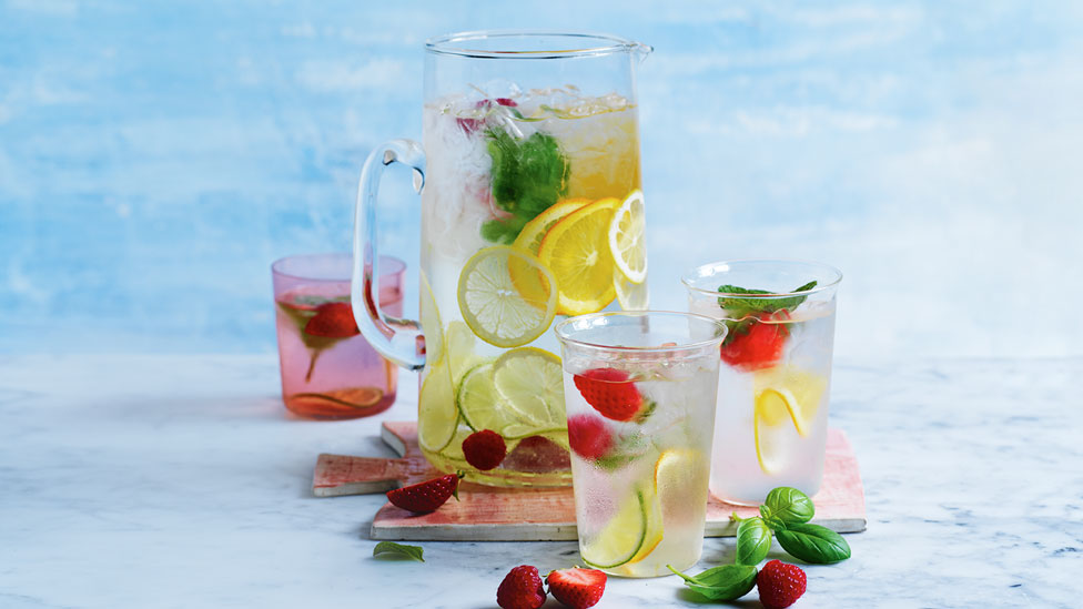 Fruit infused water in cups and jar