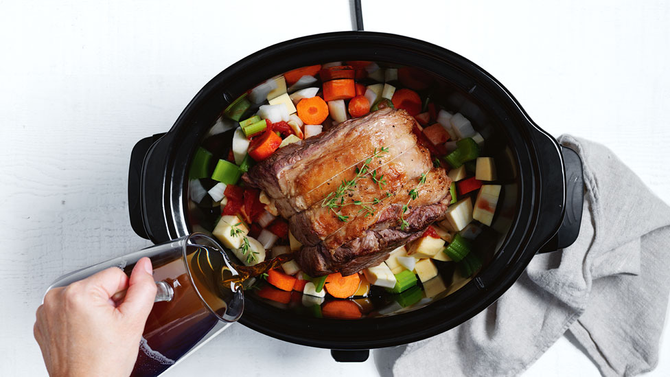 Meat and vegetables in slow cooker with the lid off