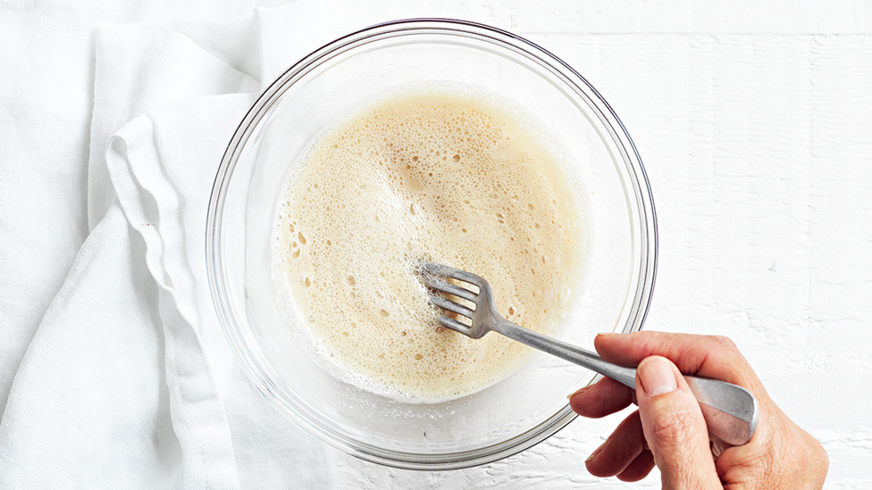 Activating yeastin a bowl being stirred with a fork