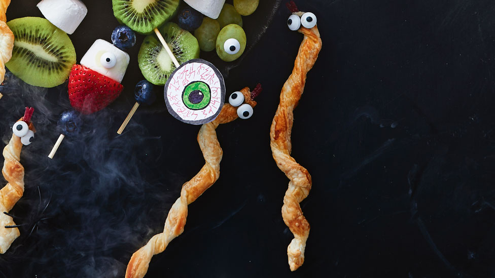 Breadsticks that look like snakes on a halloween platter