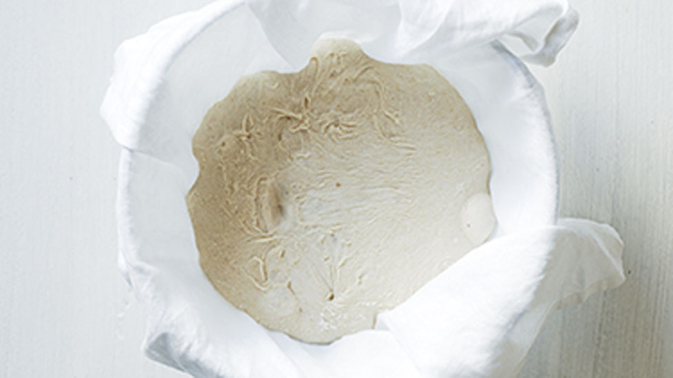 Add the dough into dusted rice flour in a muslin-lined bowl