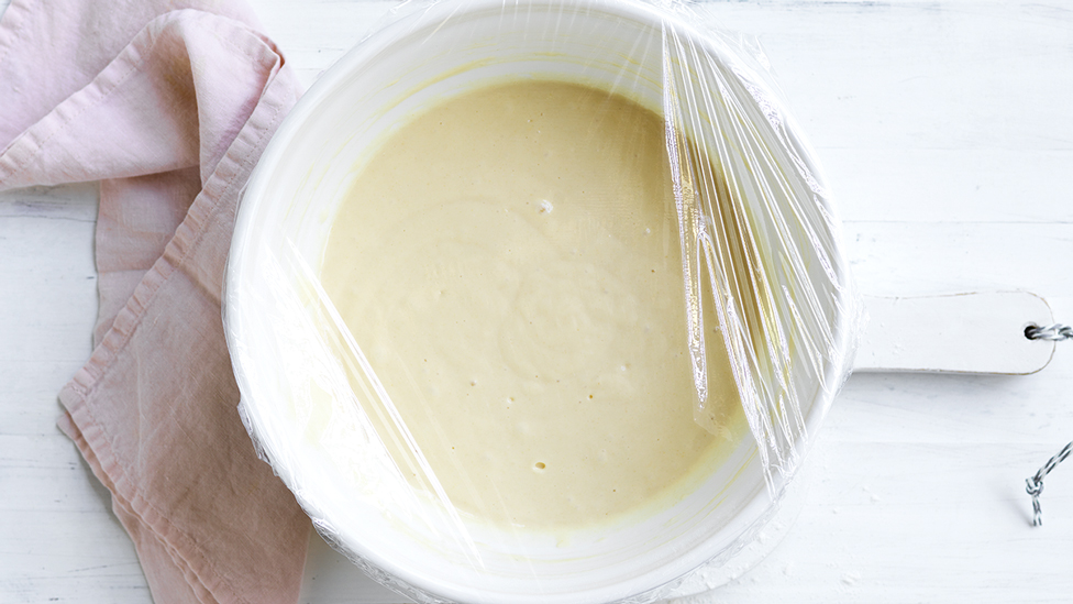 Pancake batter covered with plastic wrap